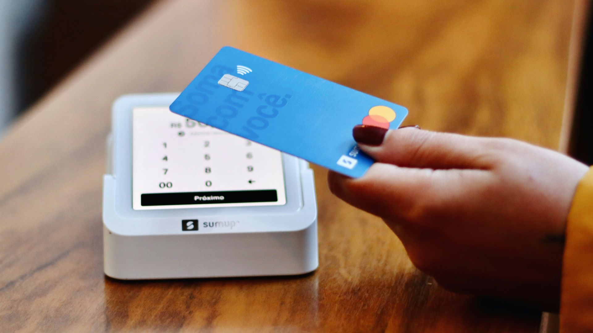 a person holding a credit card in front of a machine