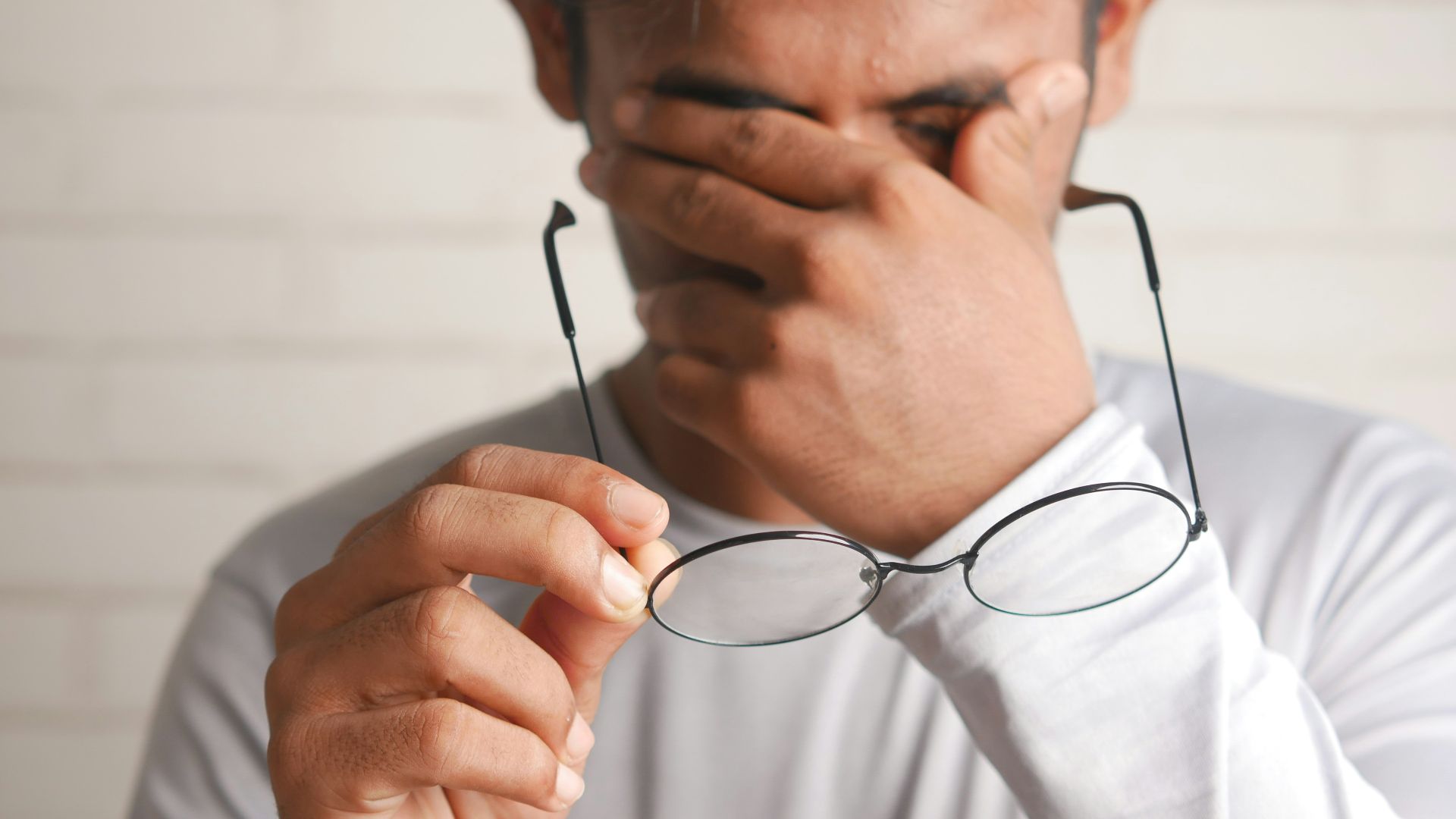 a man holding a pair of glasses up to his face