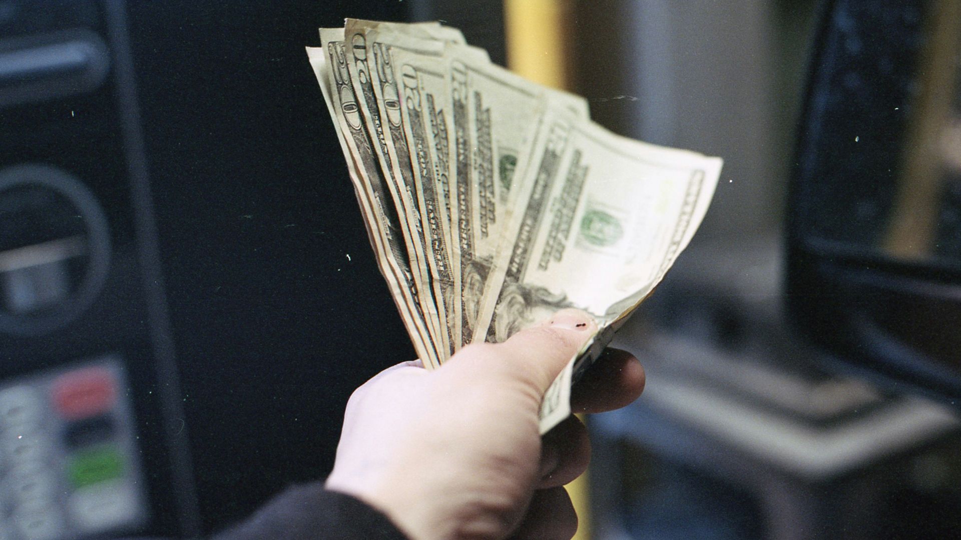 person holding fan of us dollar bill