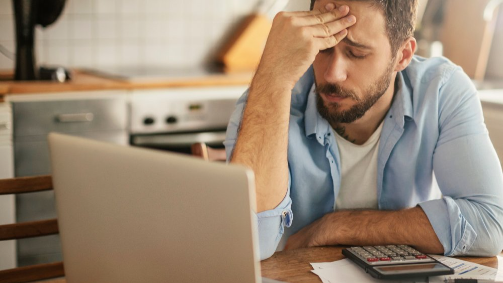 Worried young man going over his bills and home finances