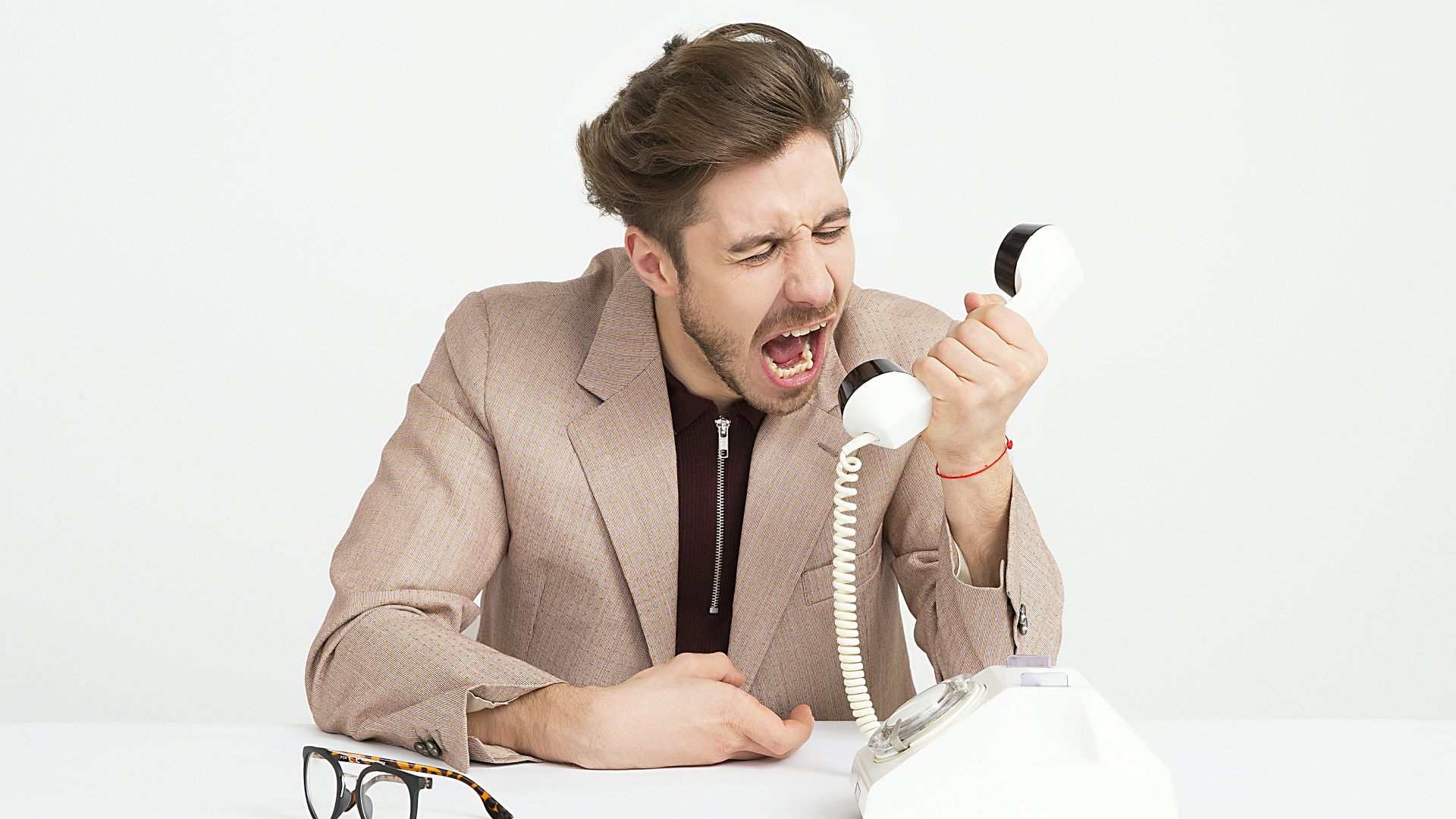 man holding telephone screaming