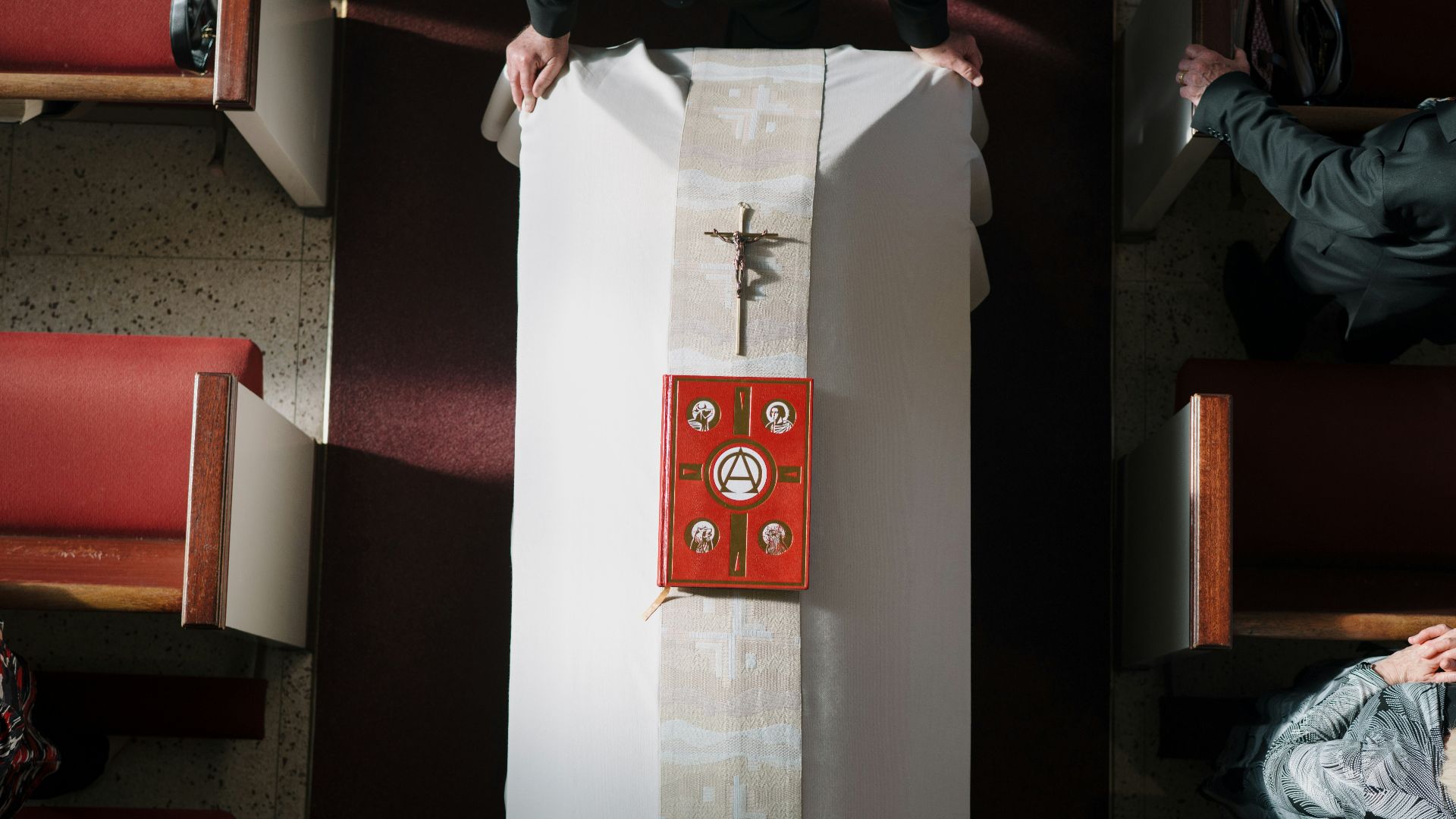 A priest prepares a church altar for service.