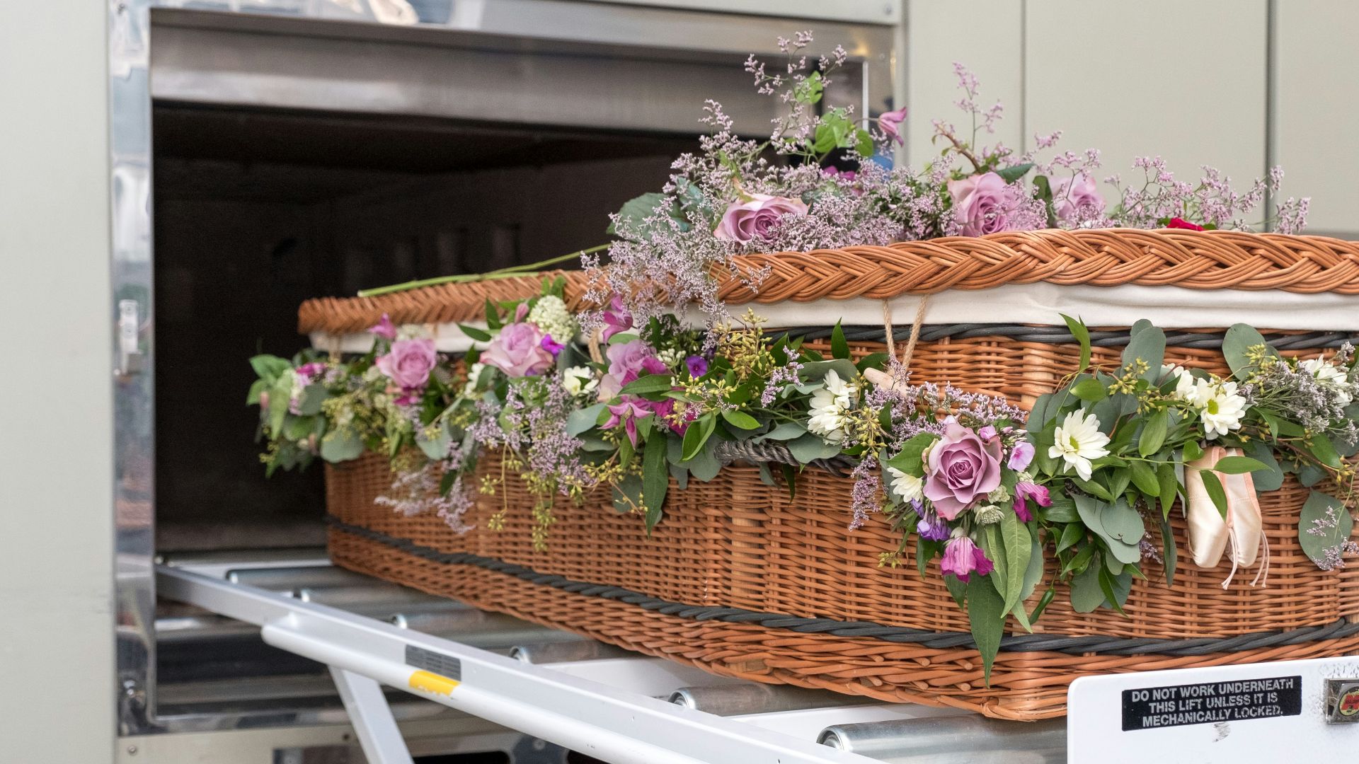 a wicker basket with flowers in it on a conveyor belt
