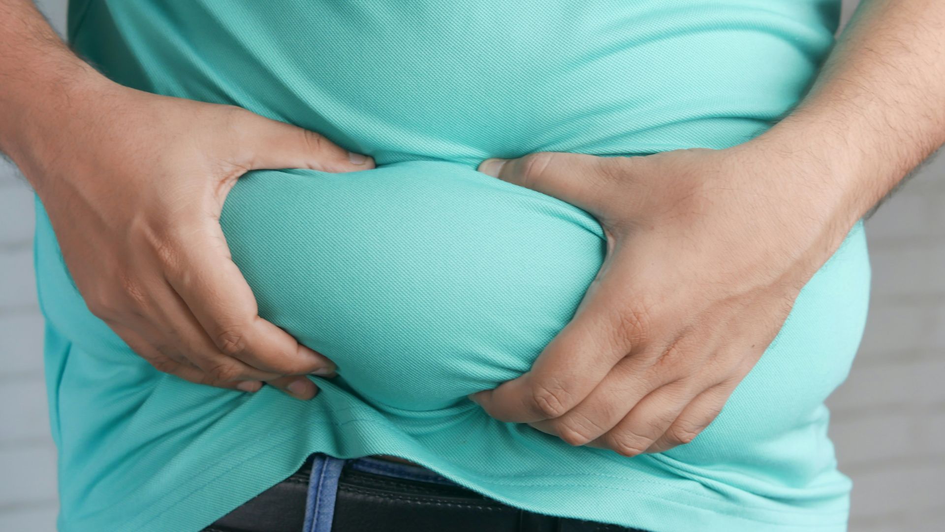 a man holding his stomach with his hands