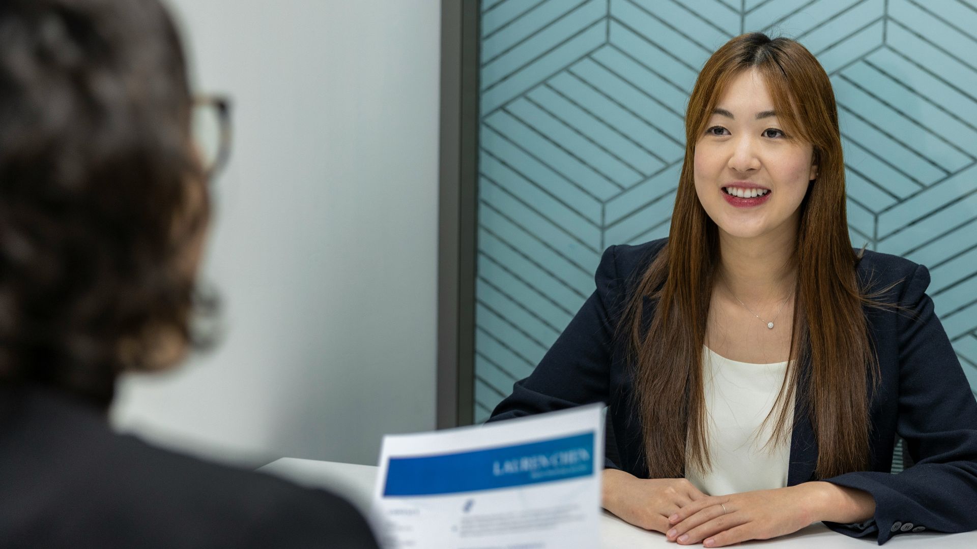 a woman sitting at a table with a piece of paper in front of her