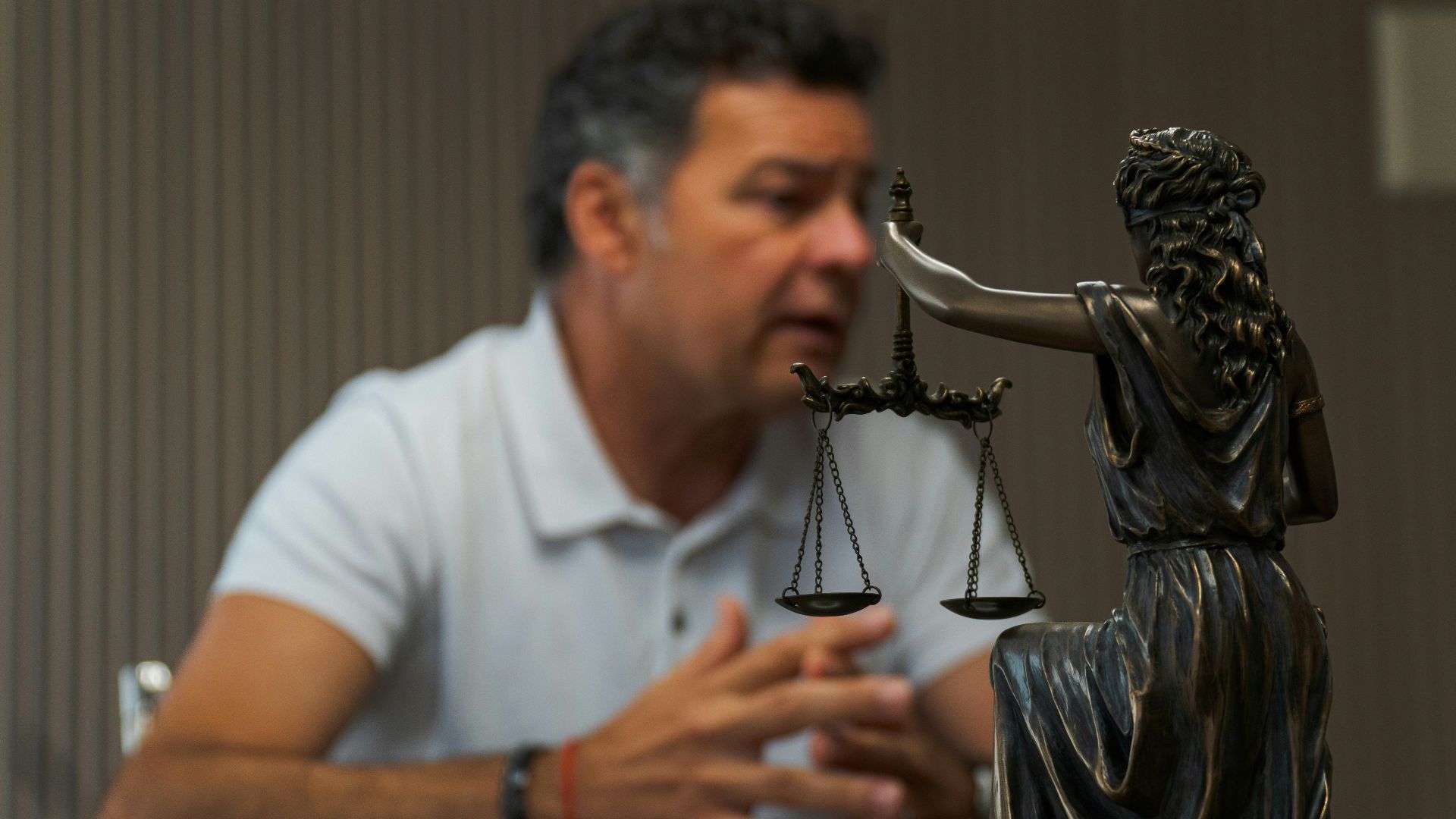 A man sitting at a table in front of a statue