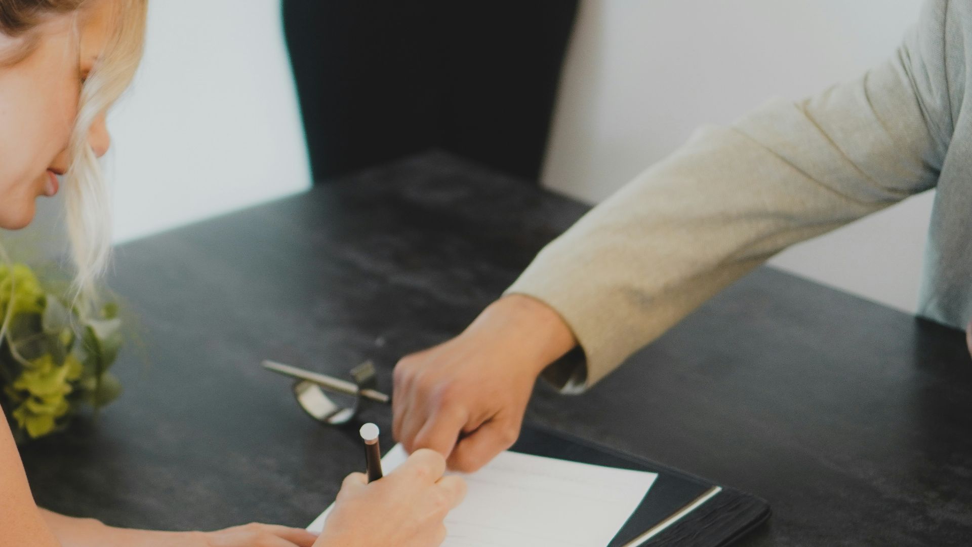 a woman showing a man something on a tablet