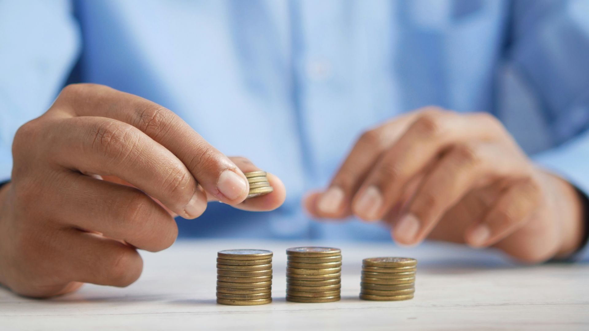 a person stacking coins on top of a table