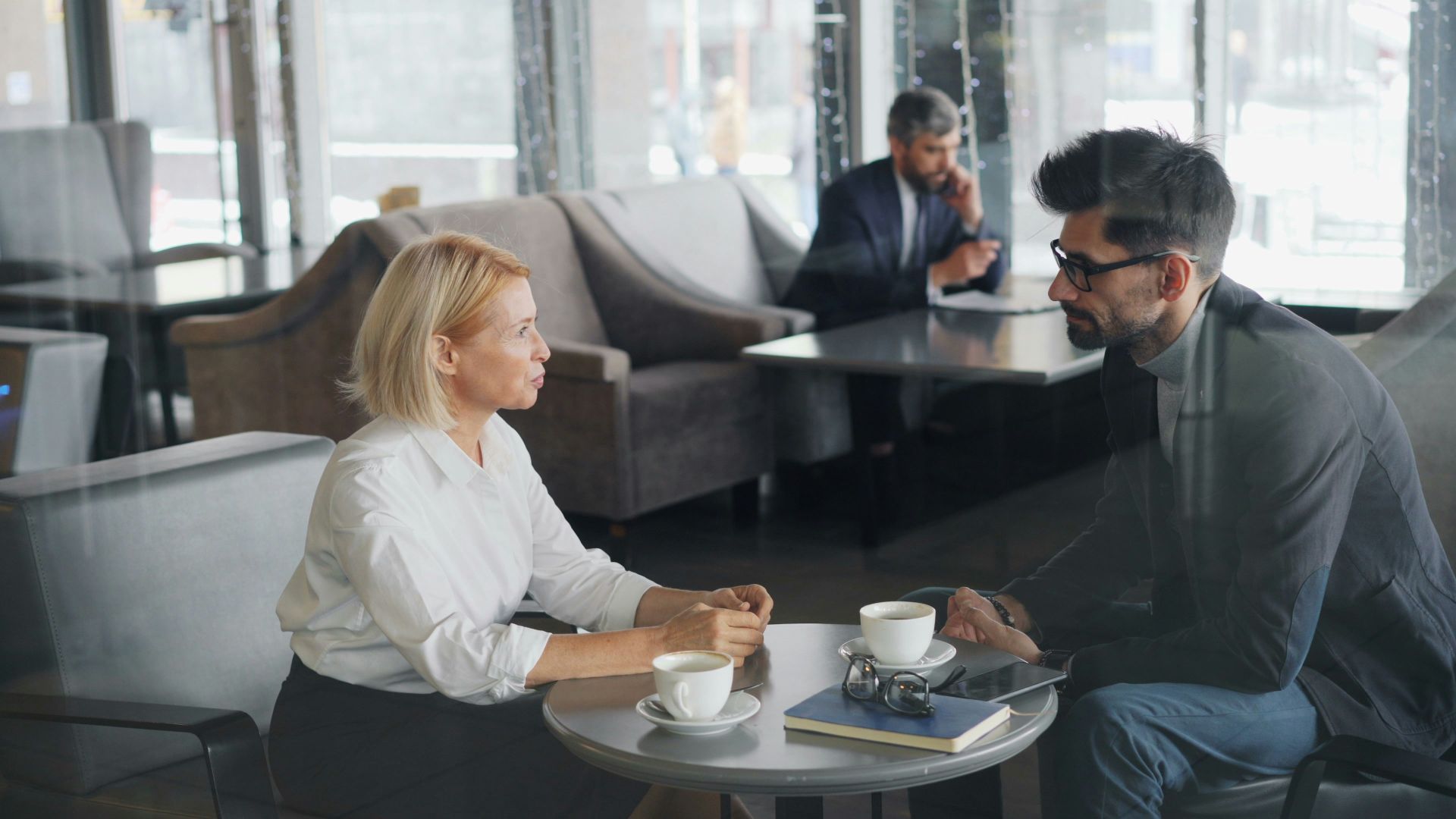 a man and a woman sitting at a table talking