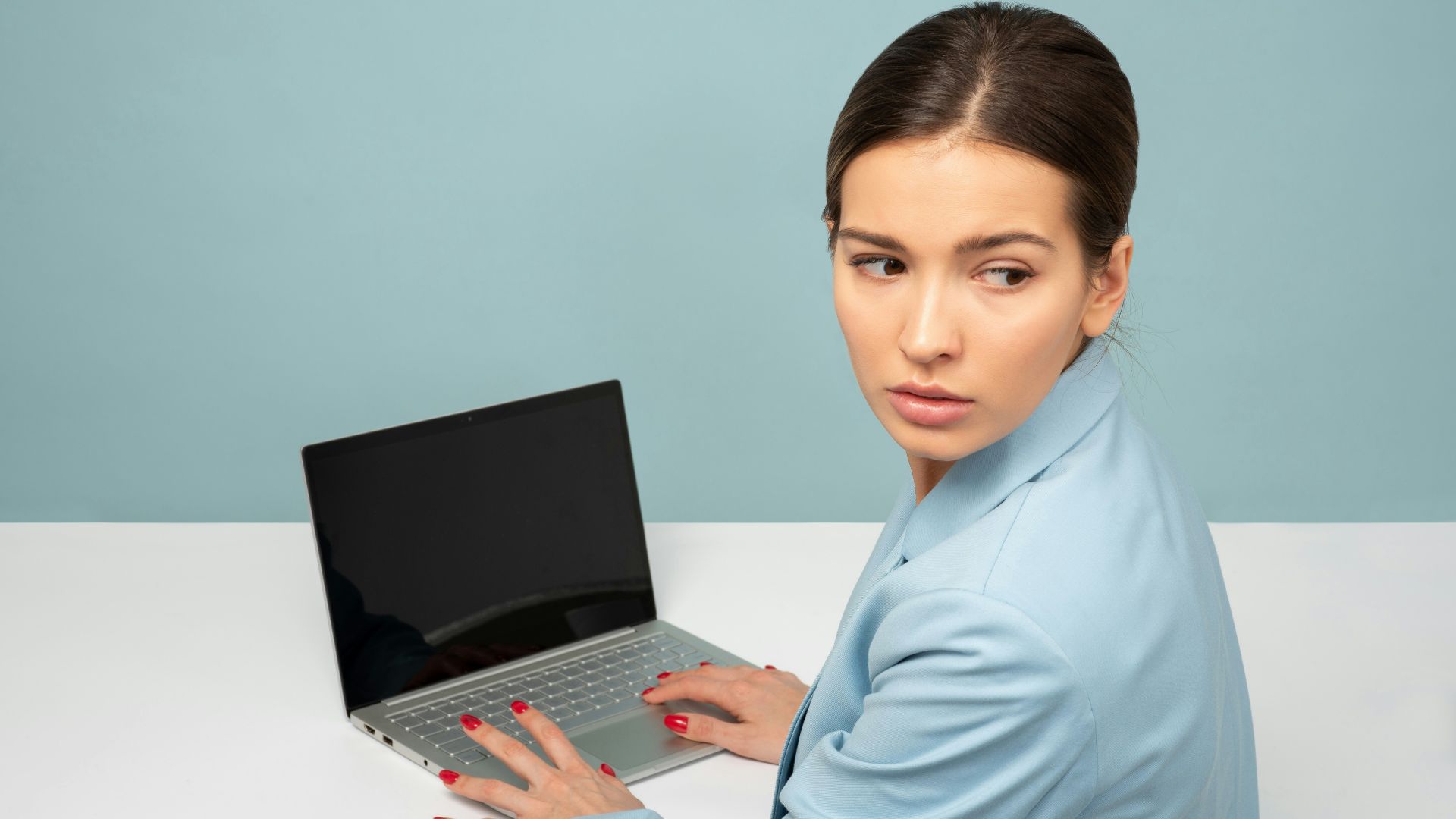woman using laptop and looking side