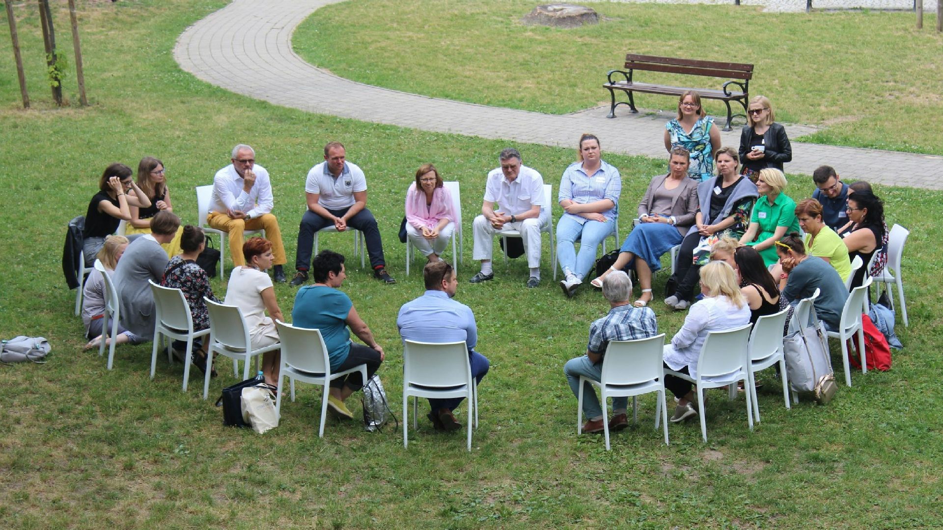 circle of people sitting on chair on grass fiedl