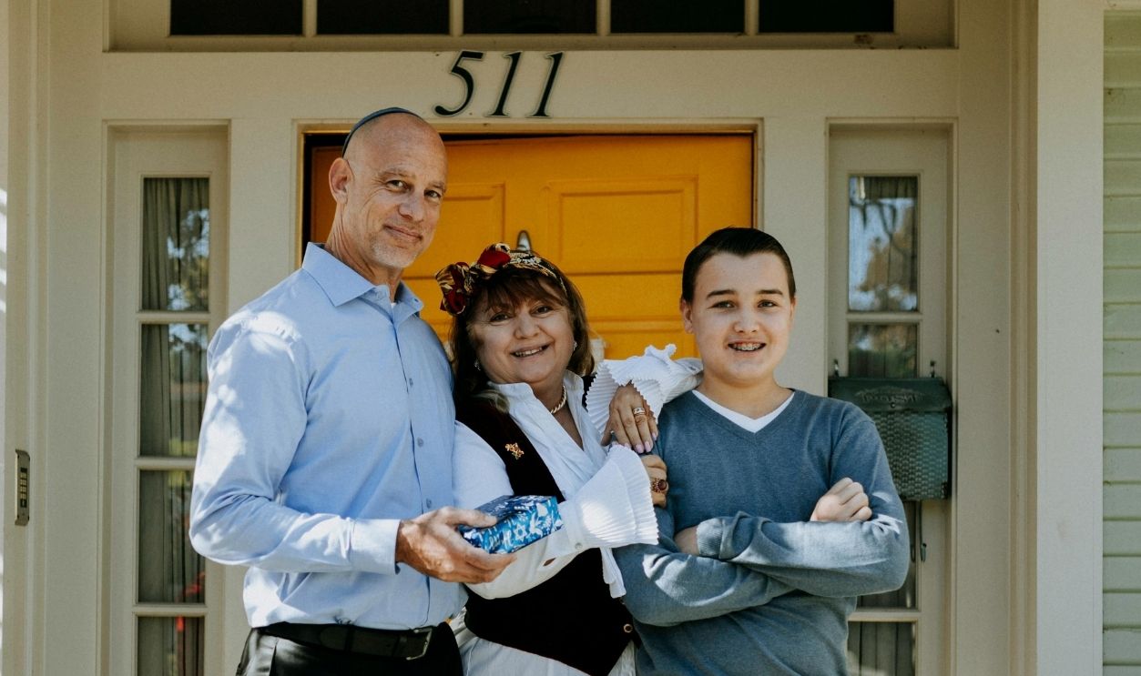 Photo Of Family Standing In Front Of House
