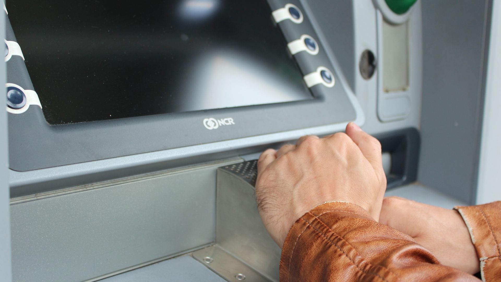 File:Person covering hand at ATM.jpg