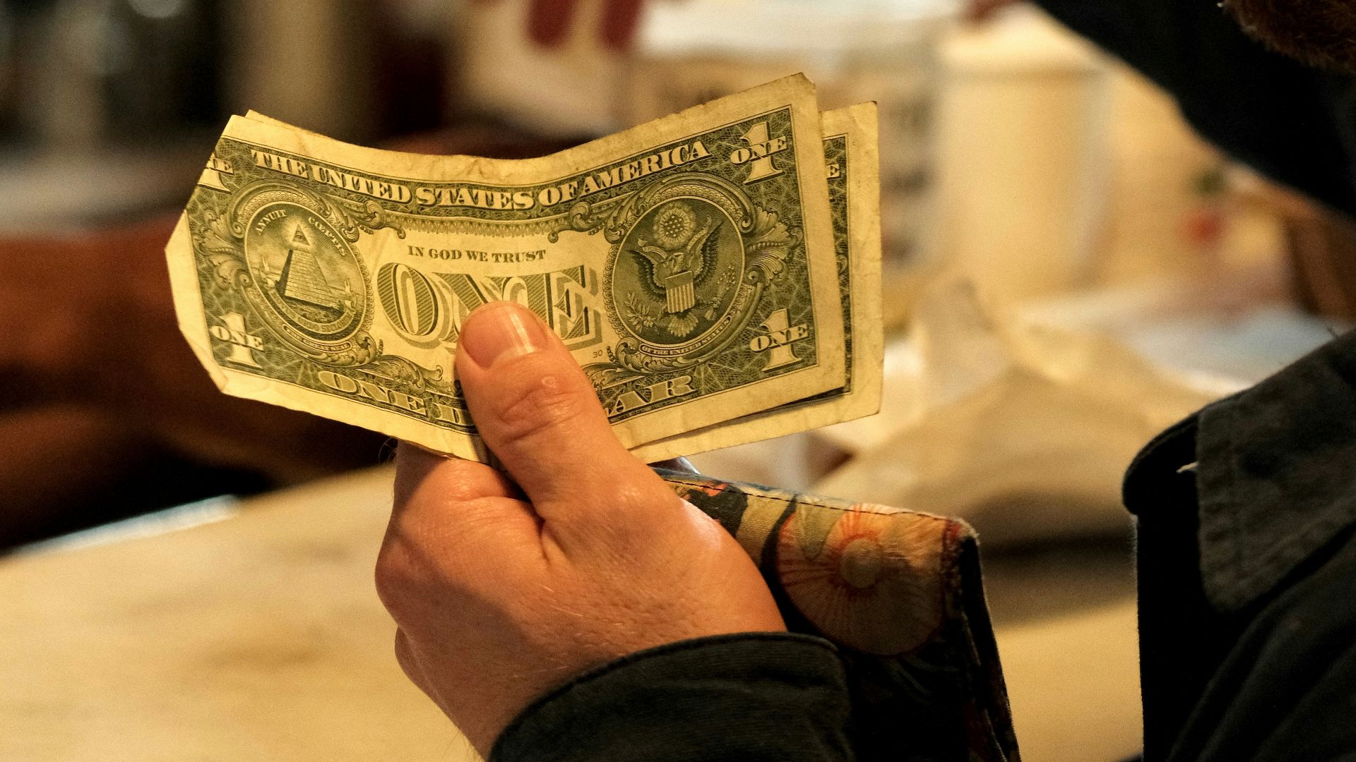 Man handing cash to someone at a counter