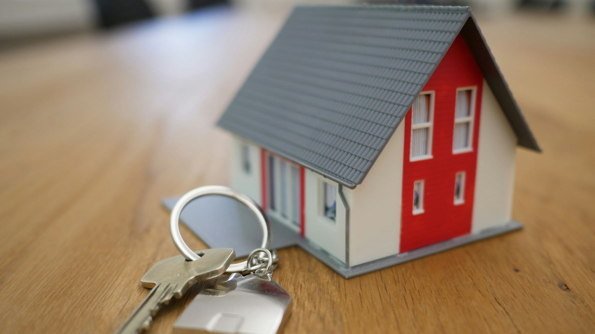 white and red wooden house miniature on brown table