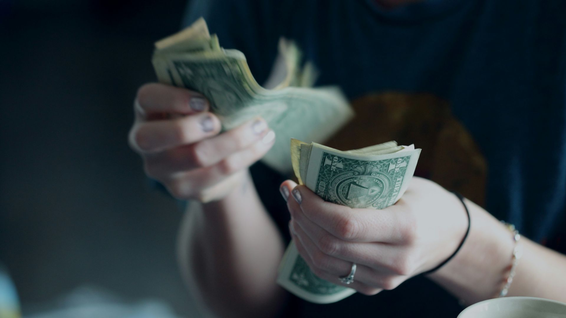 focus photography of person counting dollar banknotes