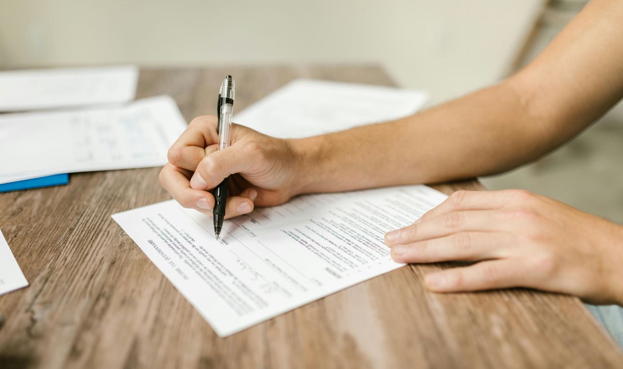 Close-Up Shot of a Person Filling Out a Form