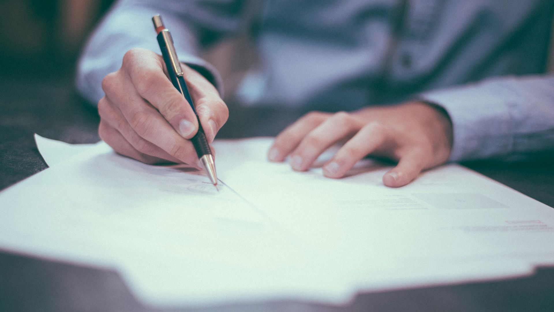 man writing on paper