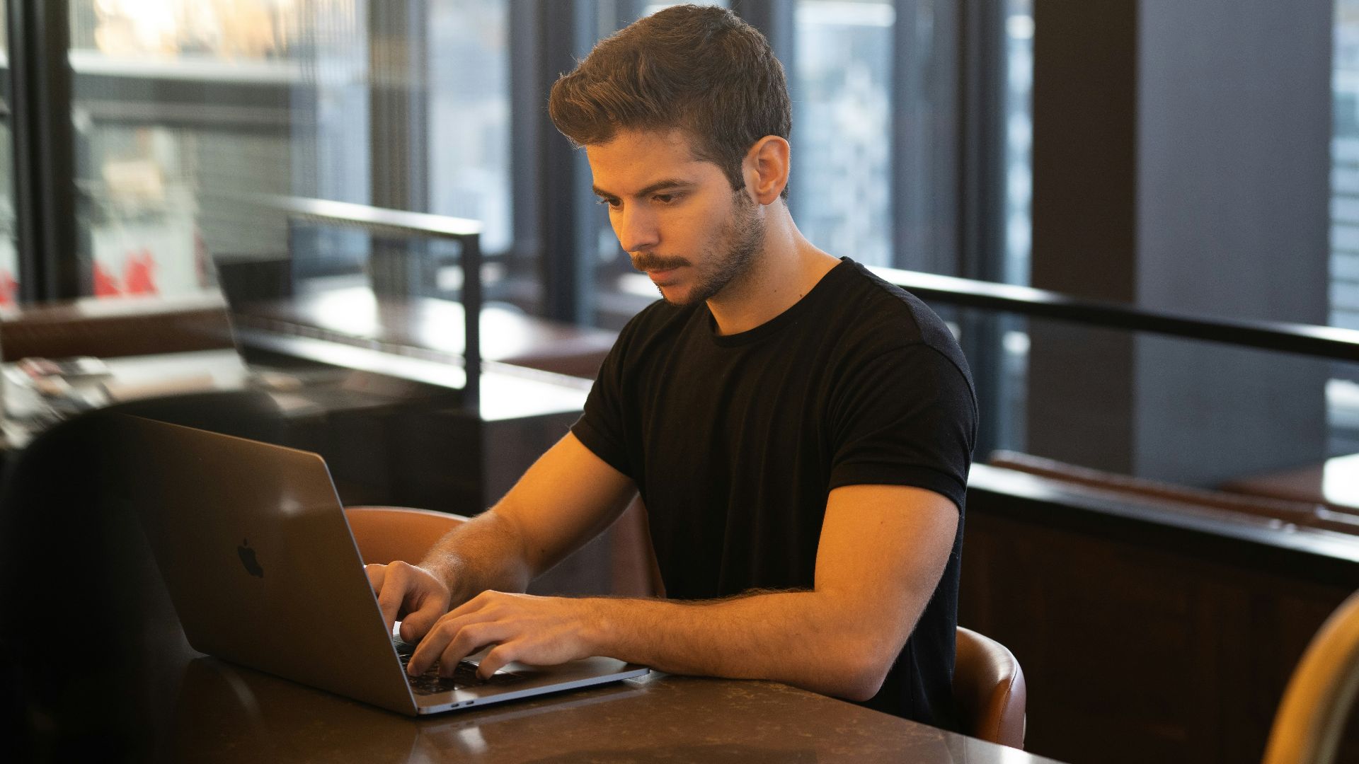 man in black crew neck t-shirt using macbook
