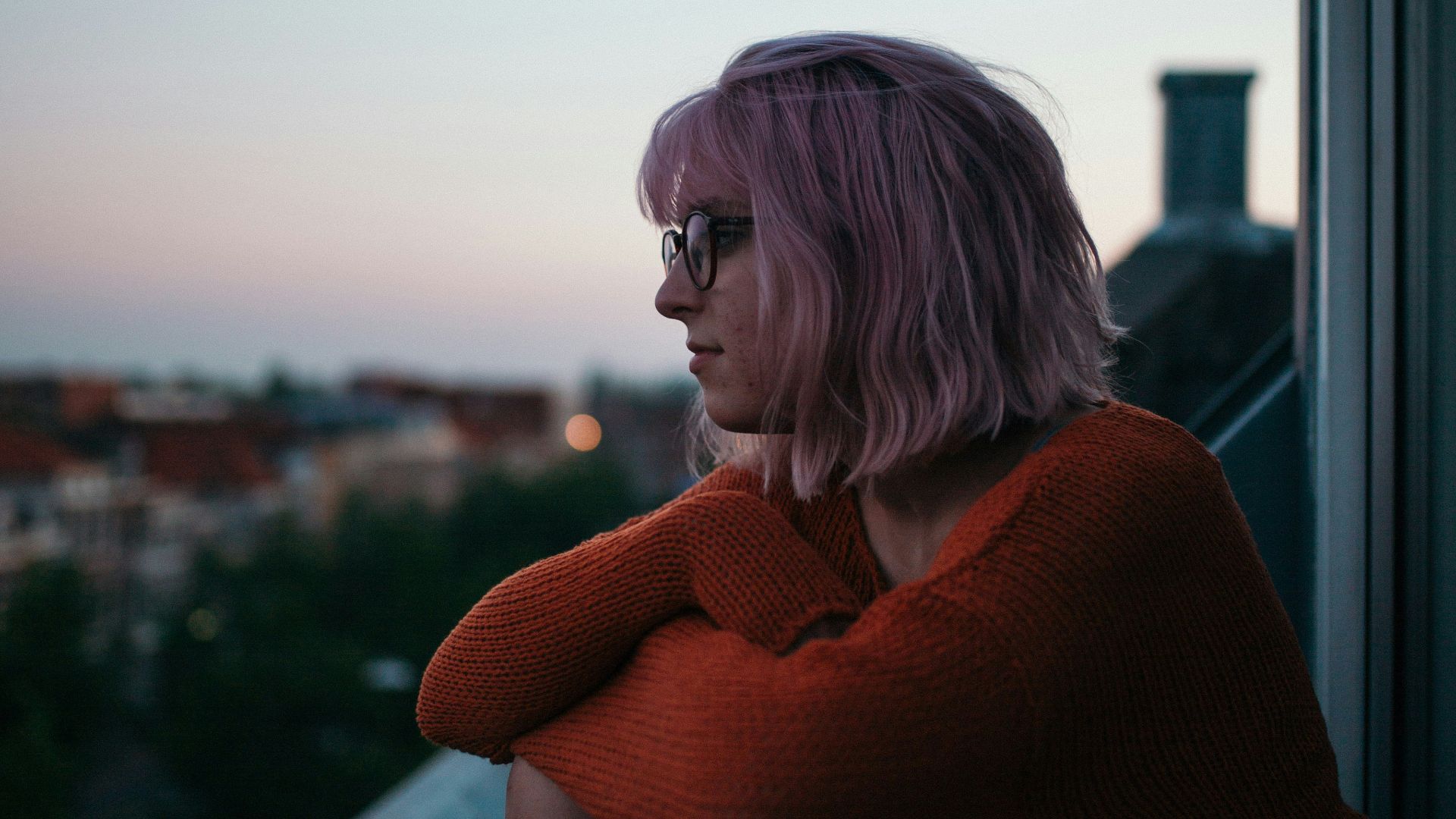 woman sitting near window near building