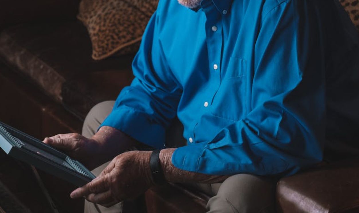 Man Sitting on a Sofa Holding a Photo Frame