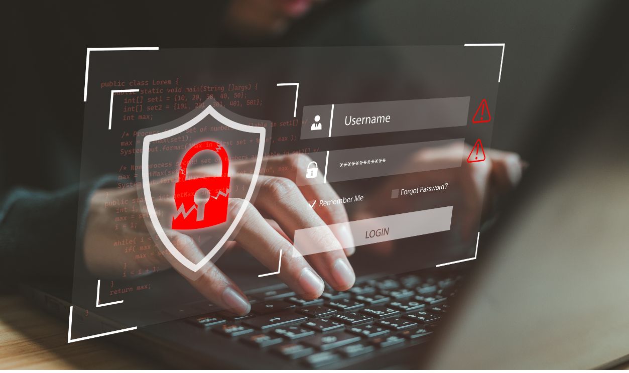 Hacker hands typing on laptop with broken security shield, login interface and programming code. Cybercrime concept showing password cracking, credential theft and unauthorized system penetration.