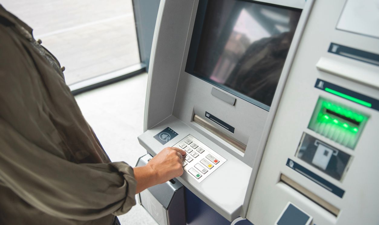 Female hand Typing PIN number at ATM machine, entry code for electronic banking