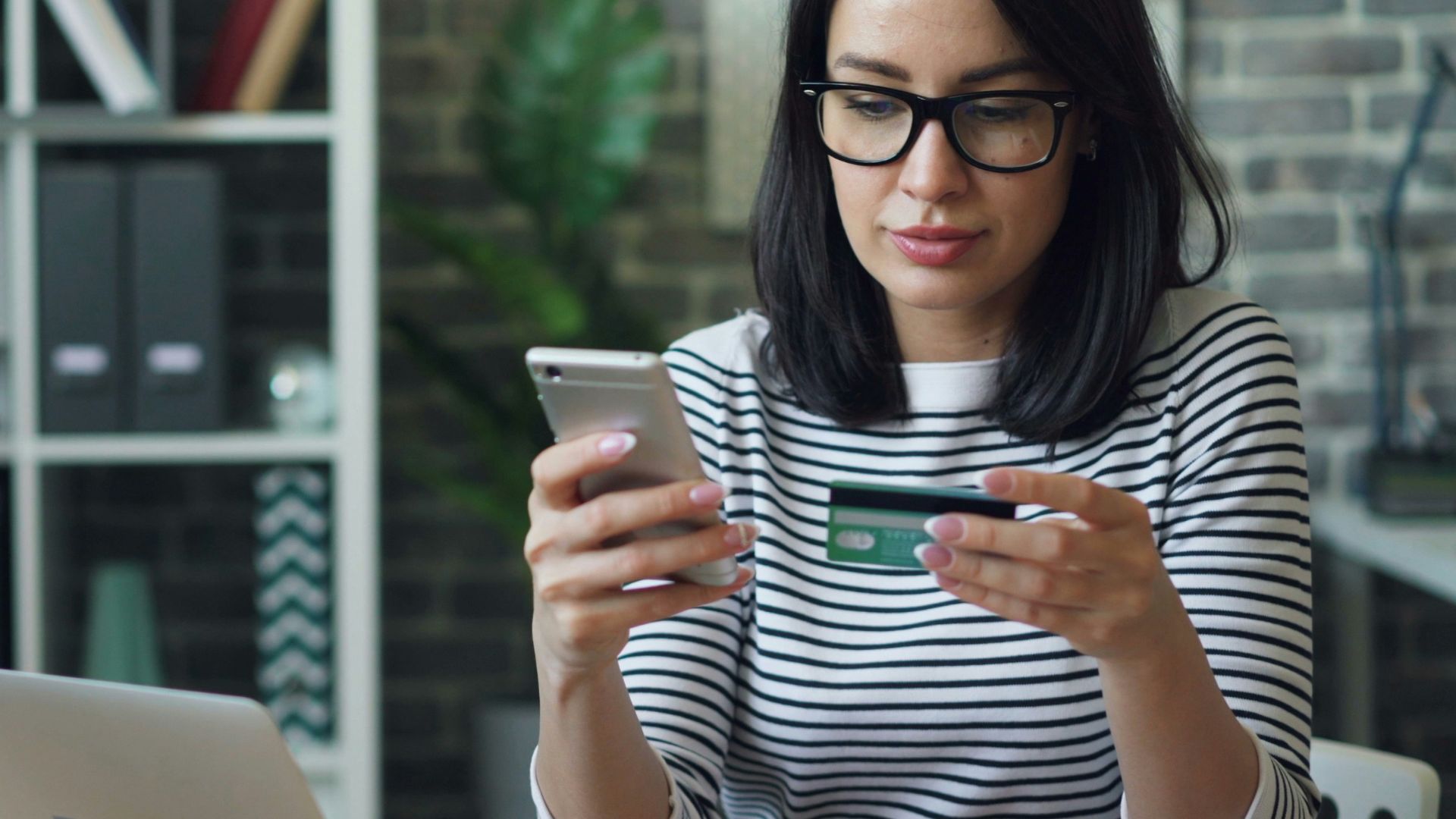 a woman sitting at a table looking at her cell phone