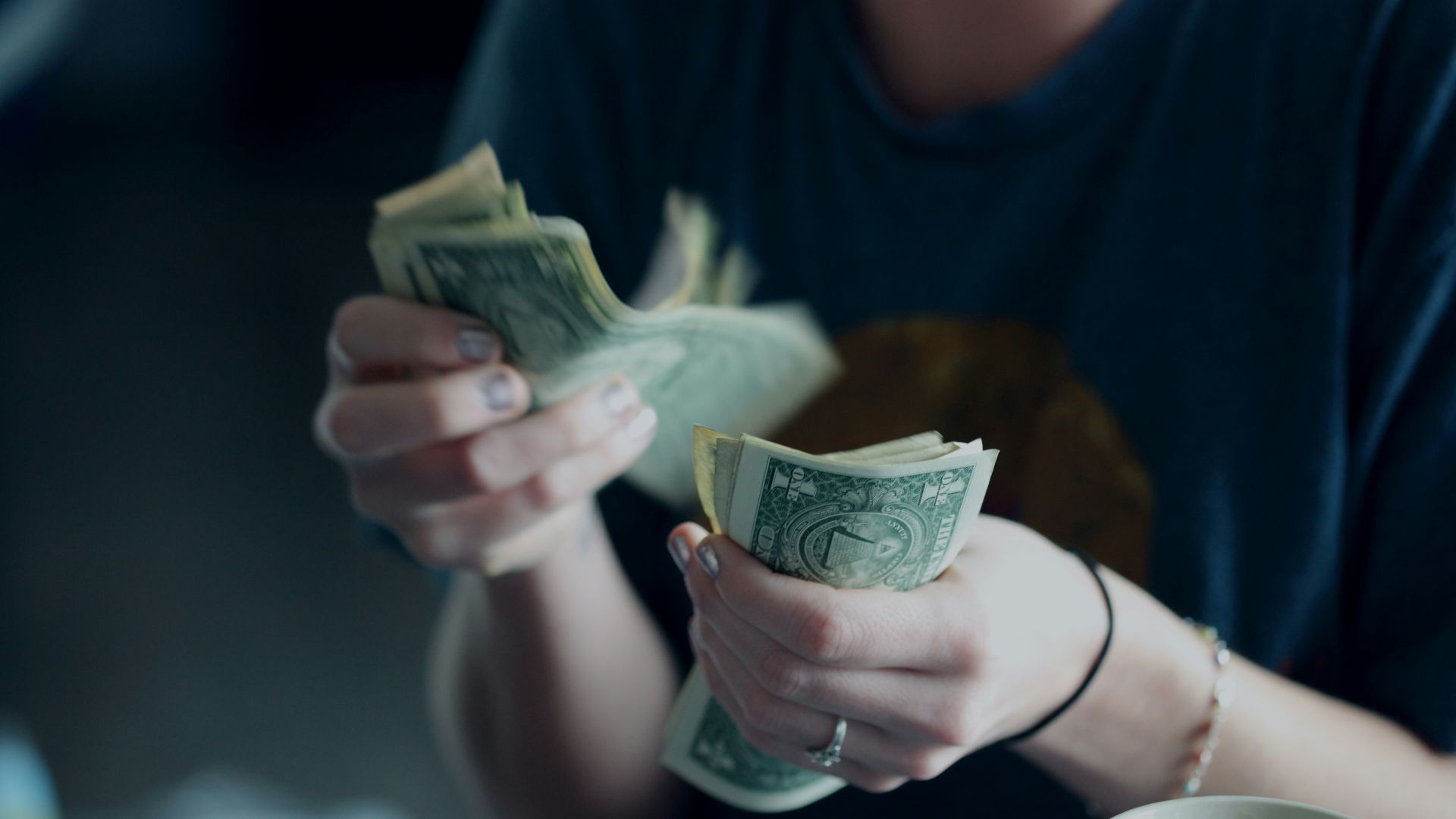 focus photography of person counting dollar banknotes