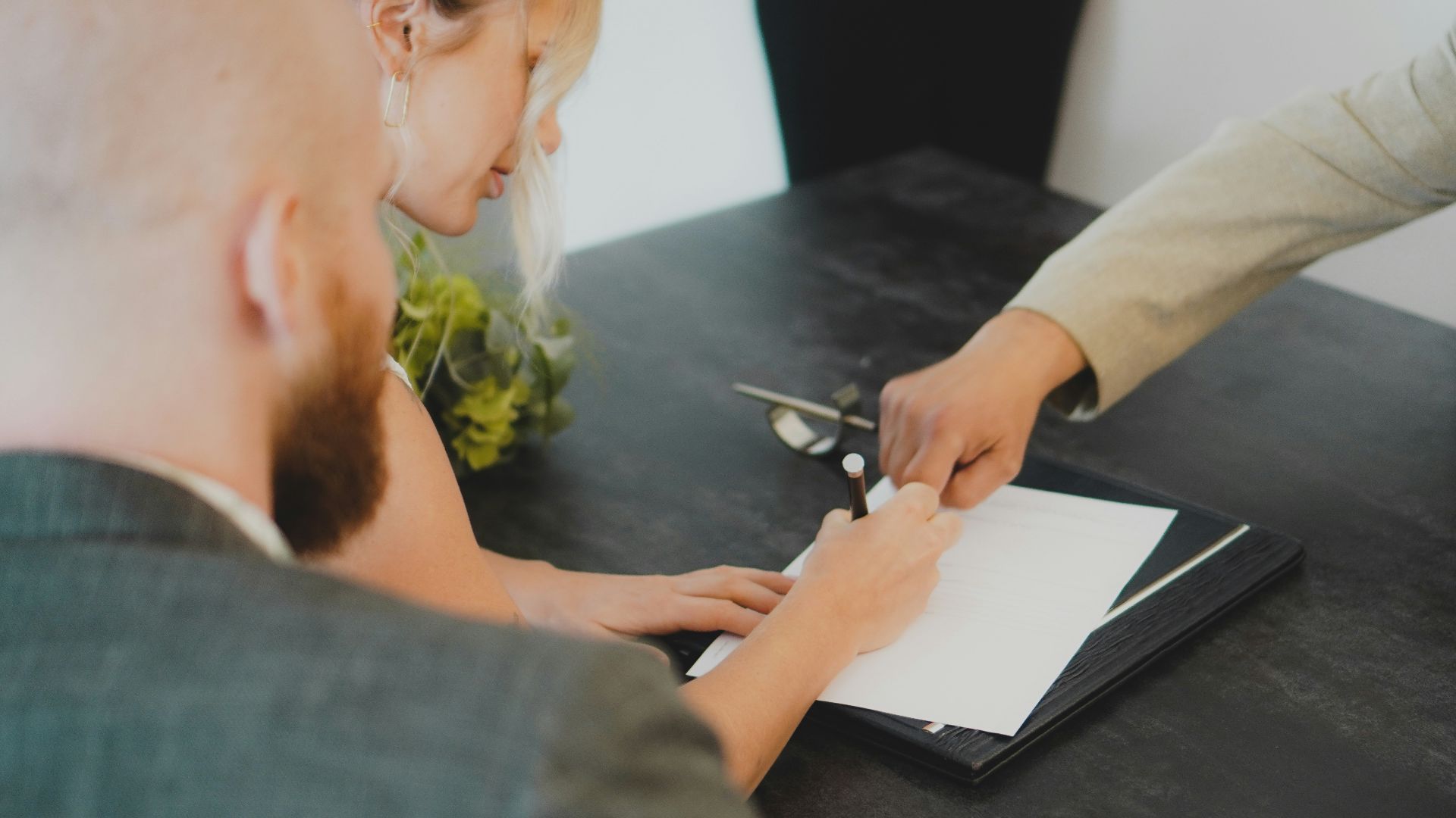 a woman showing a man something on a tablet