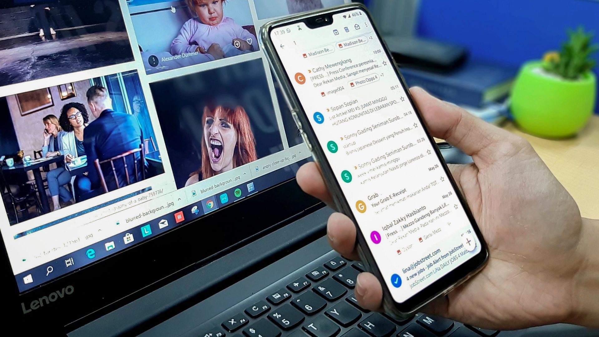 person using smartphone and laptop computer