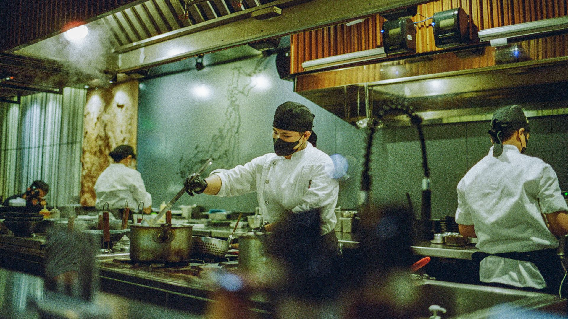 A group of chefs preparing food in a kitchen