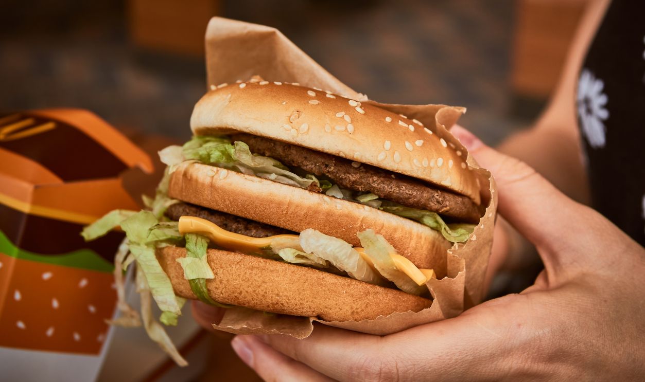 Burger in hand. Big tasty burger in the girl's hand. Big Mac.