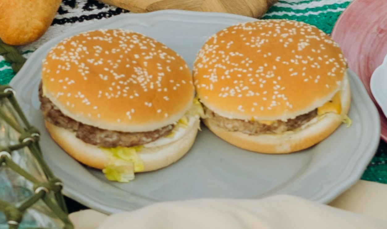 Two juicy homemade burgers on a plate, perfect for an appetizing meal.
