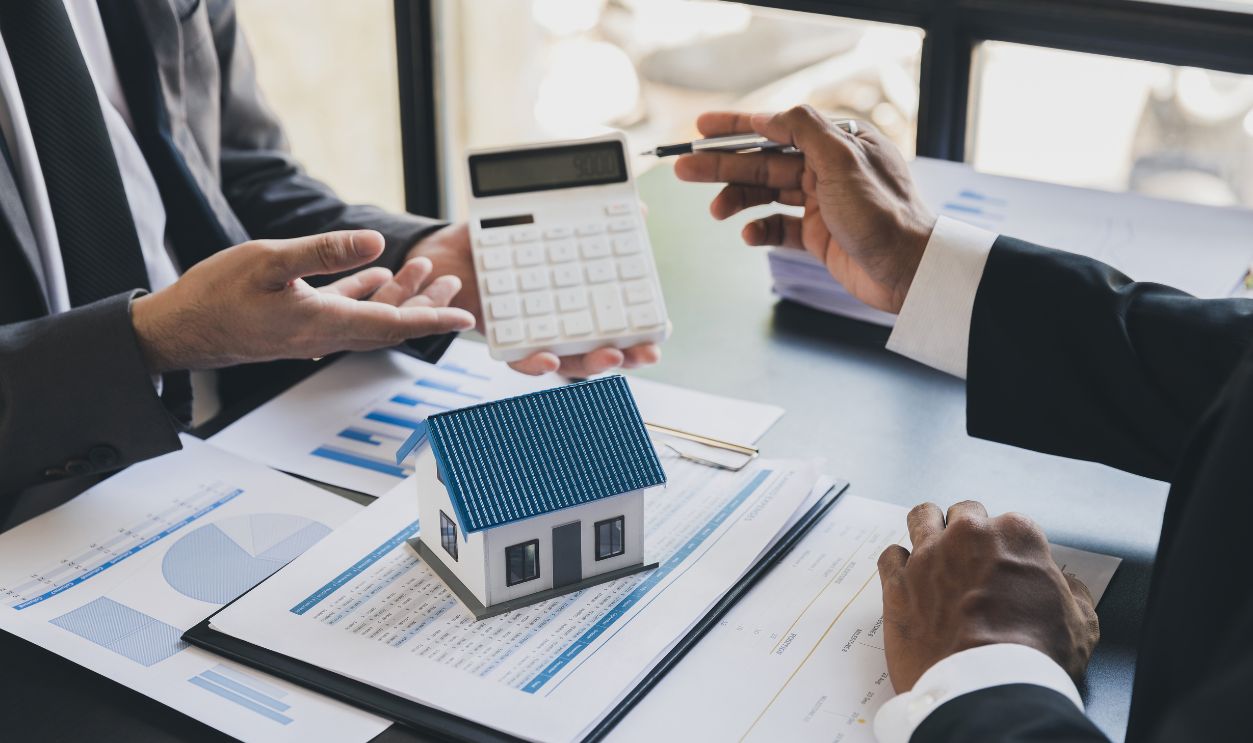 House model with agent and customer discussing calculate for price contract to buy, get insurance or loan real estate or property.