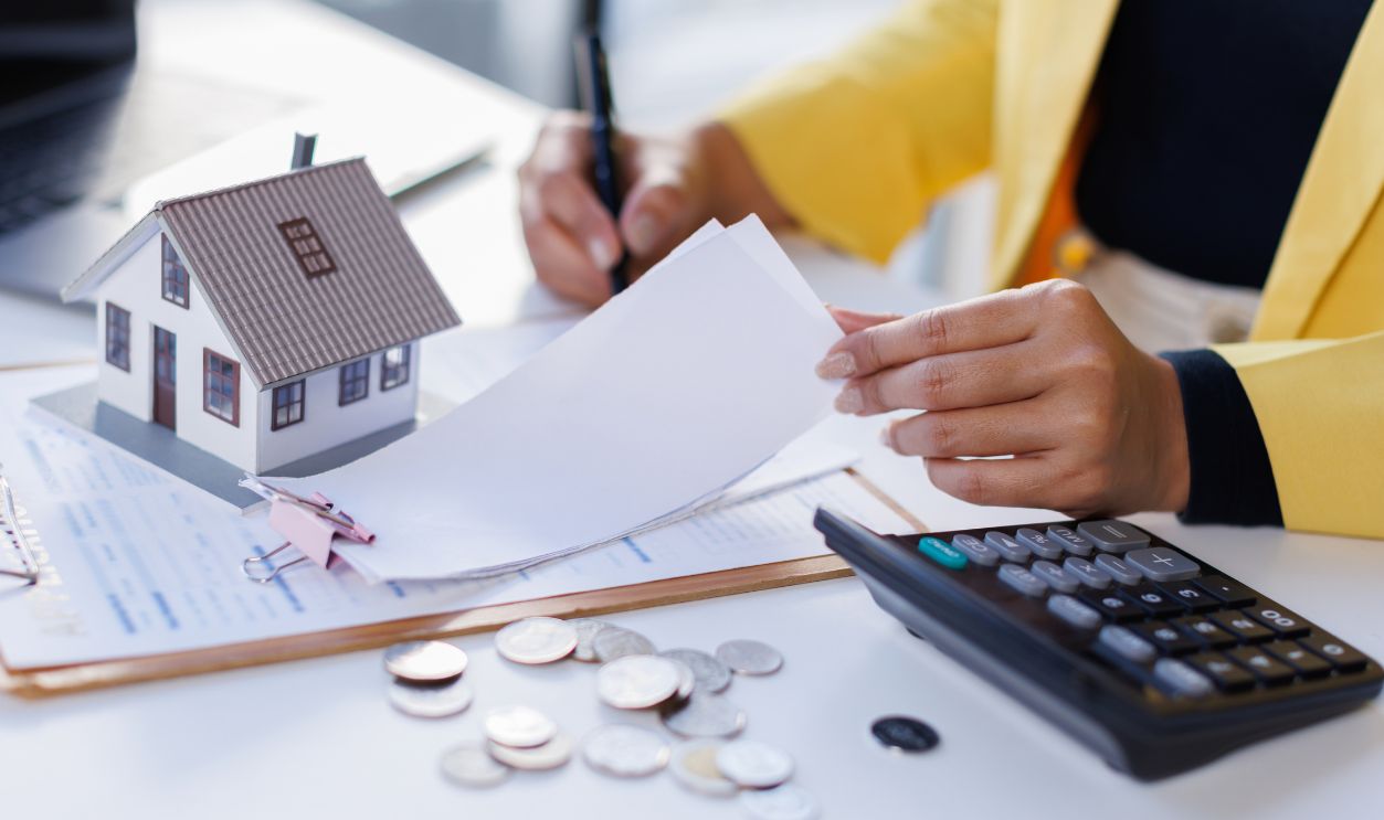 Mortgage Real Estate, woman hand using calculator to calculate home finance, accounting on bell, budget management. Doing finance, budgeting and tax calculation, monthly expenses