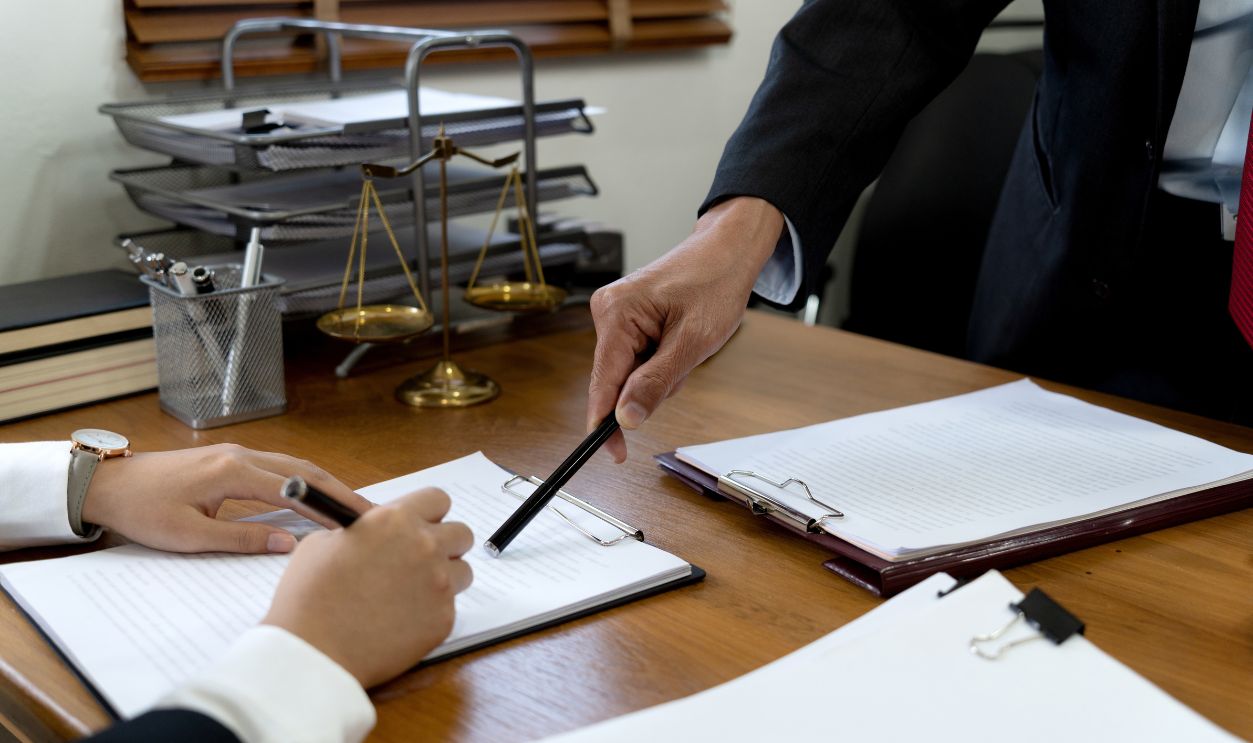 Law firms discussing with pen pointing at documents drafting or amending contracts in law firm office