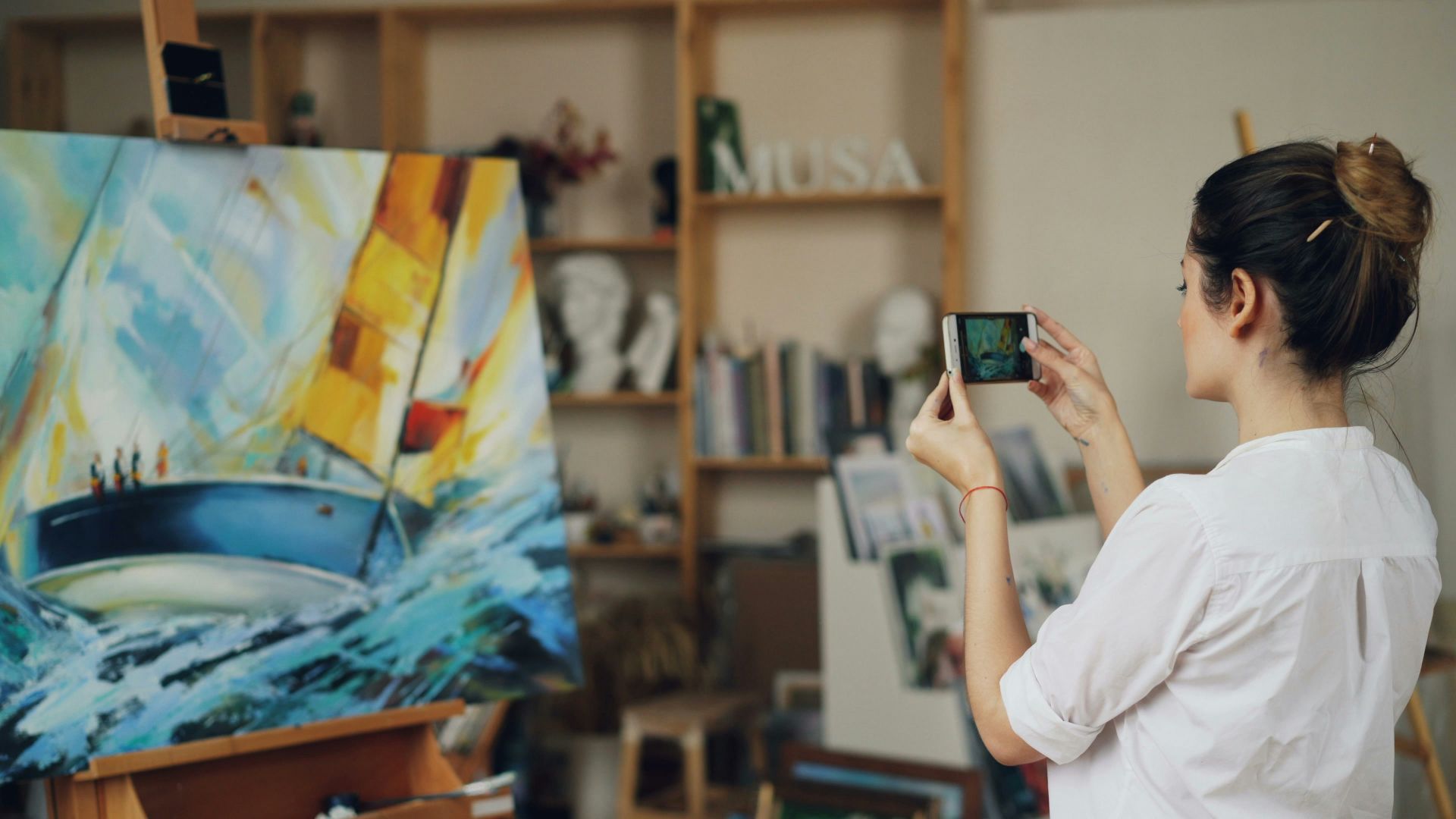 Woman takes a photo of her painting