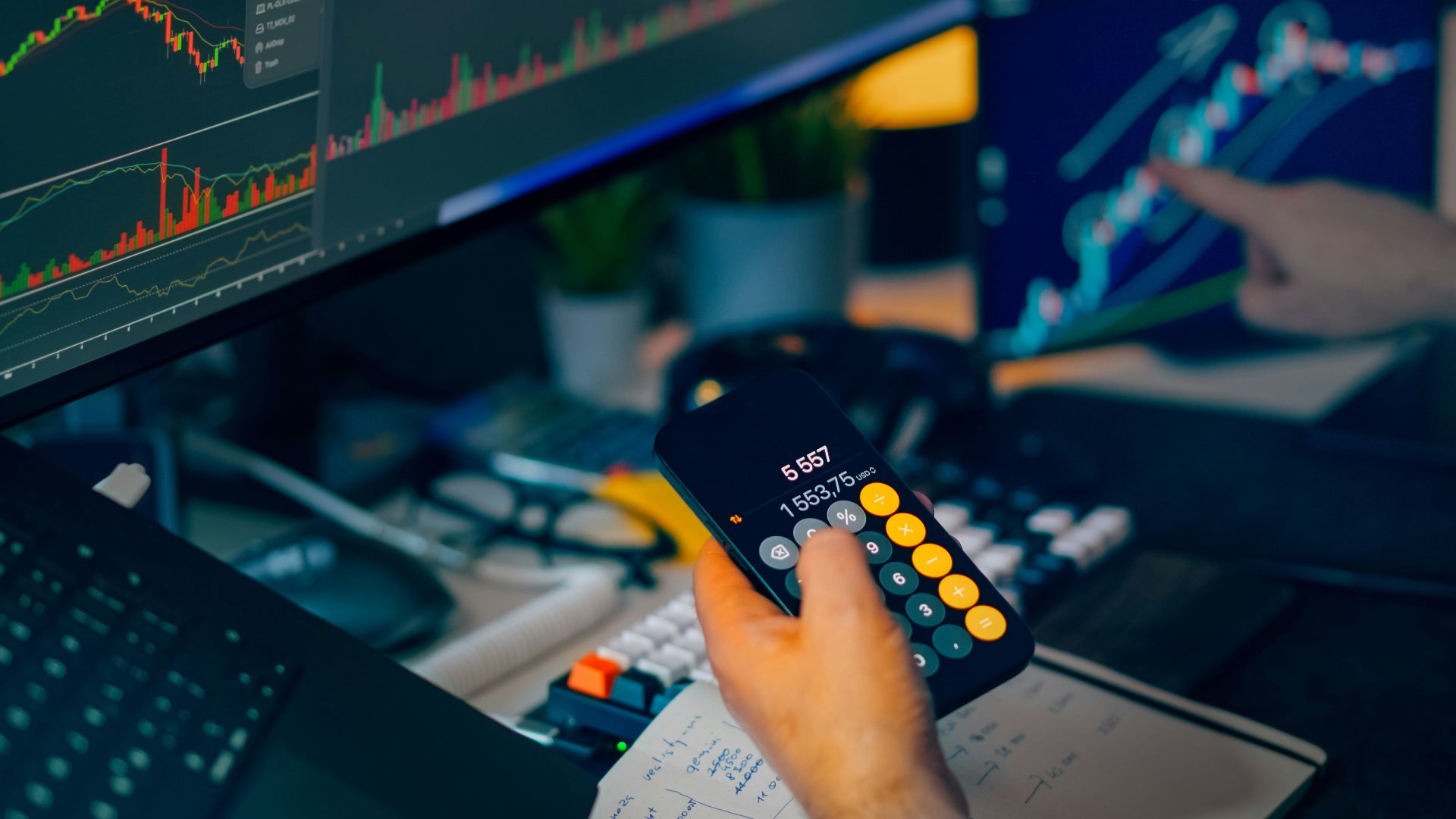 Trader analyzing stock market charts on computer screens with calculator