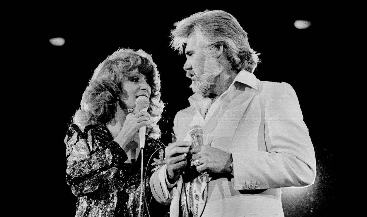 Getty Images - 1268715156 - American Country musicians Dottie West (1932 - 1991) and Kenny Rogers (1938 - 2020) perform together onstage at Nassau Coliseum, Uniondale, New York, September 26, 1980.
