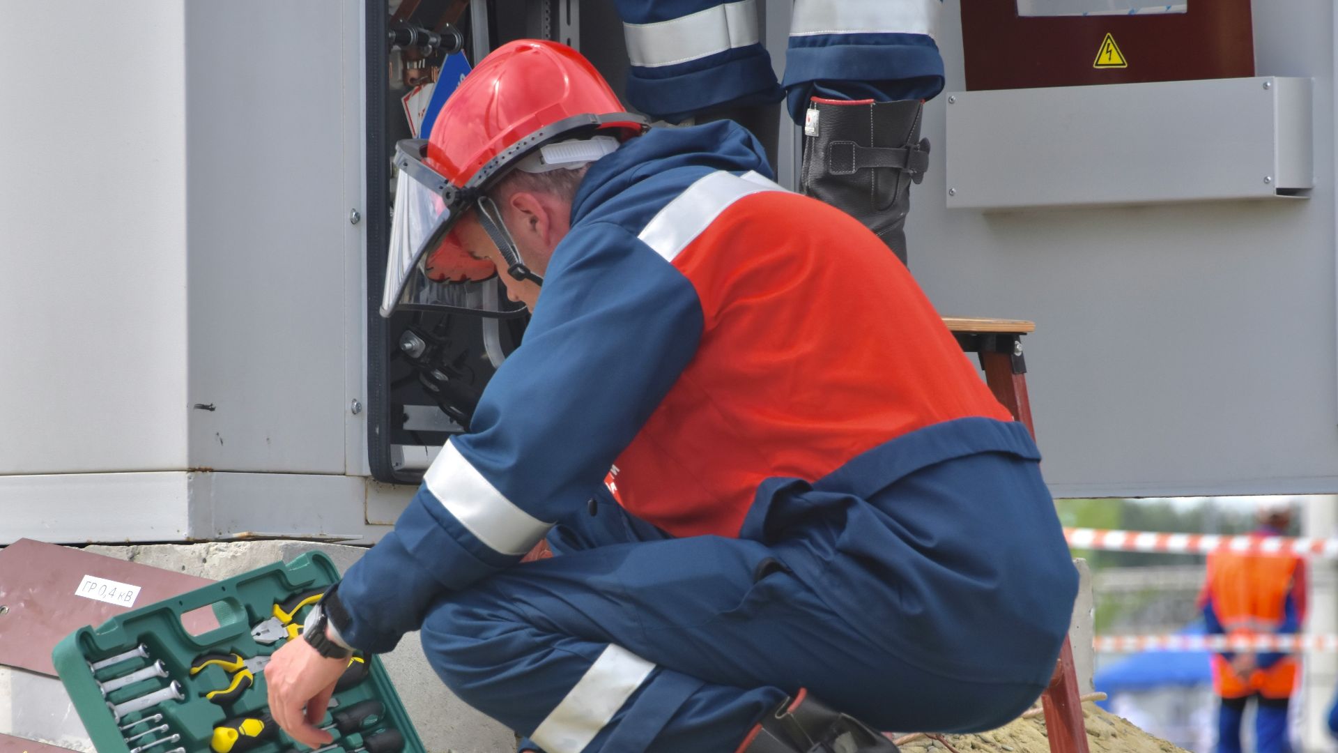 man in red and black jacket wearing black pants and red helmet holding green and black