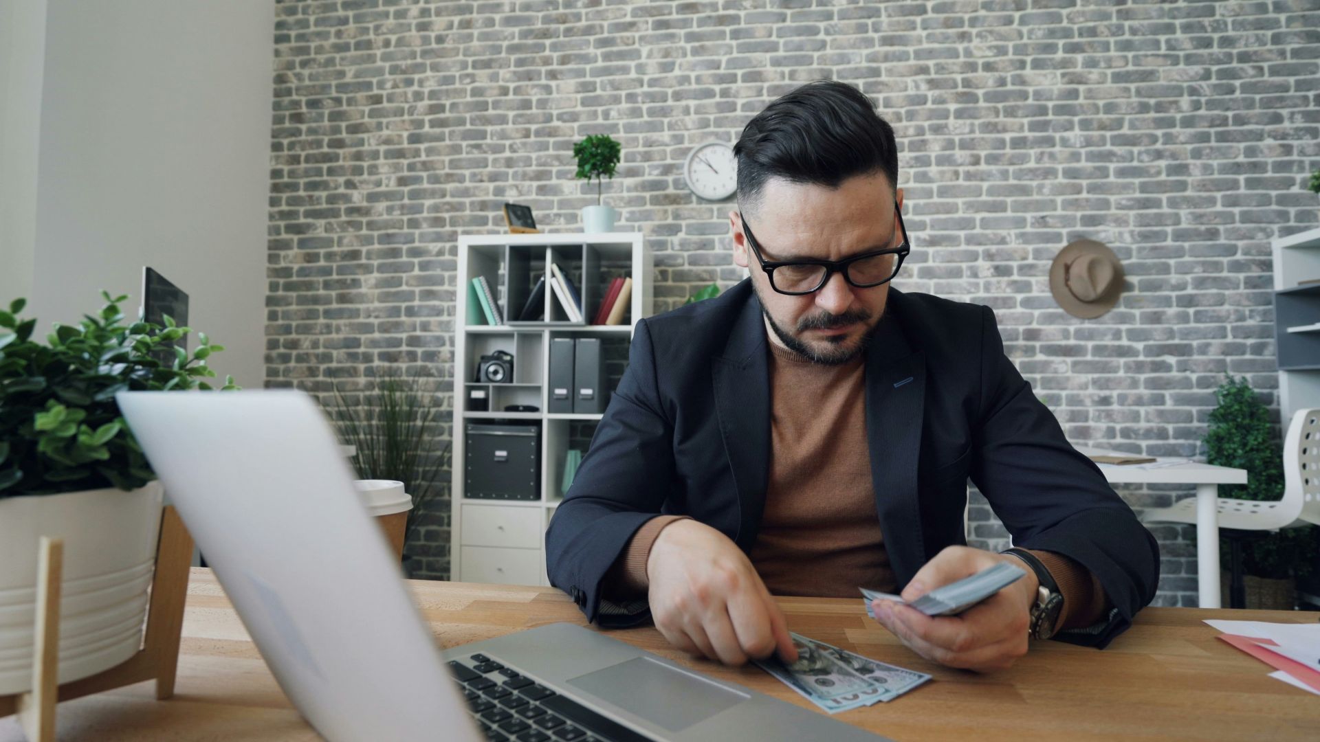 a man sitting at a table in front of a laptop