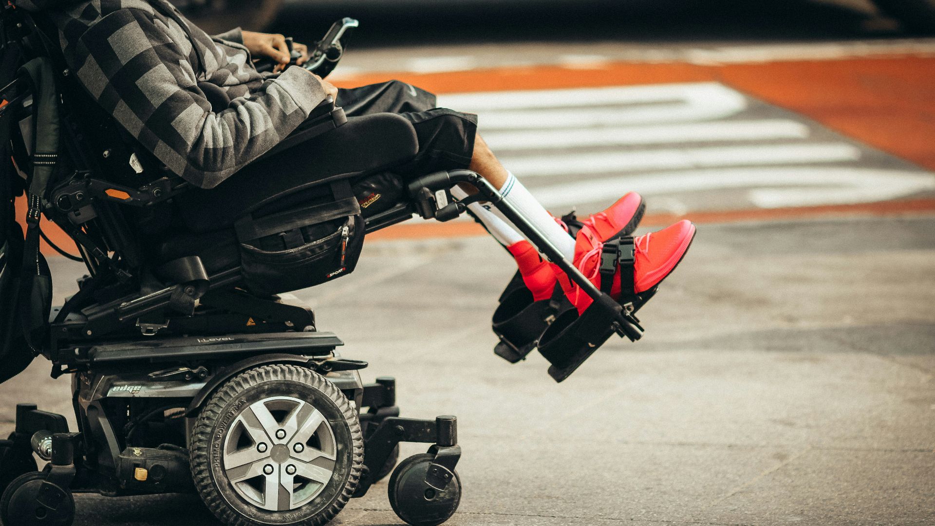 man in brown jacket and black pants riding black and red motorcycle