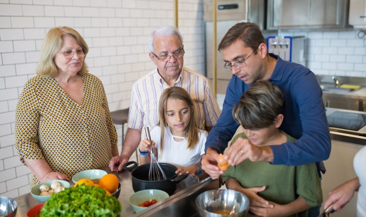 A diverse family enjoys cooking together in a modern kitchen setting.
