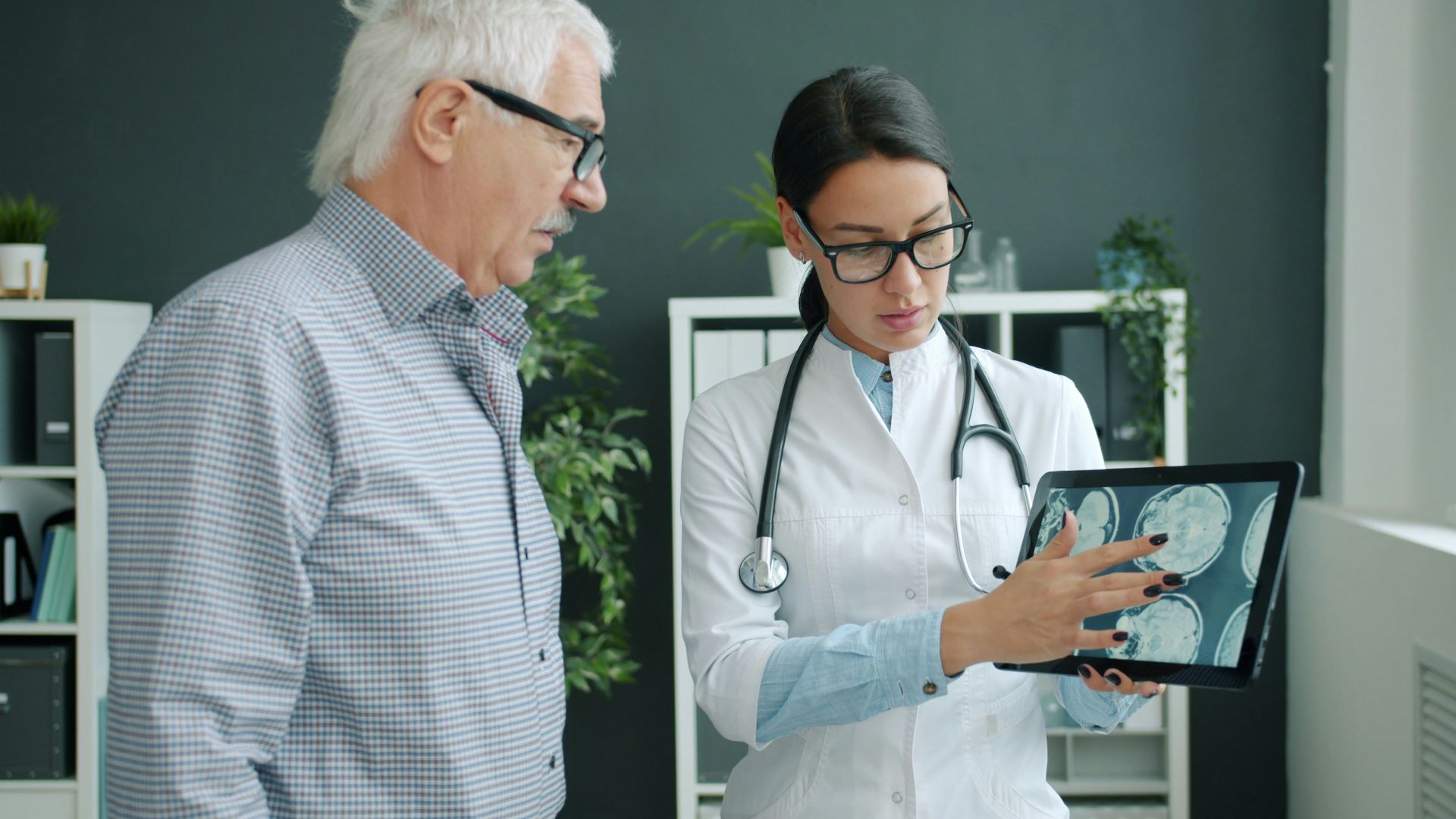 Doctor shows medical scan to elderly patient