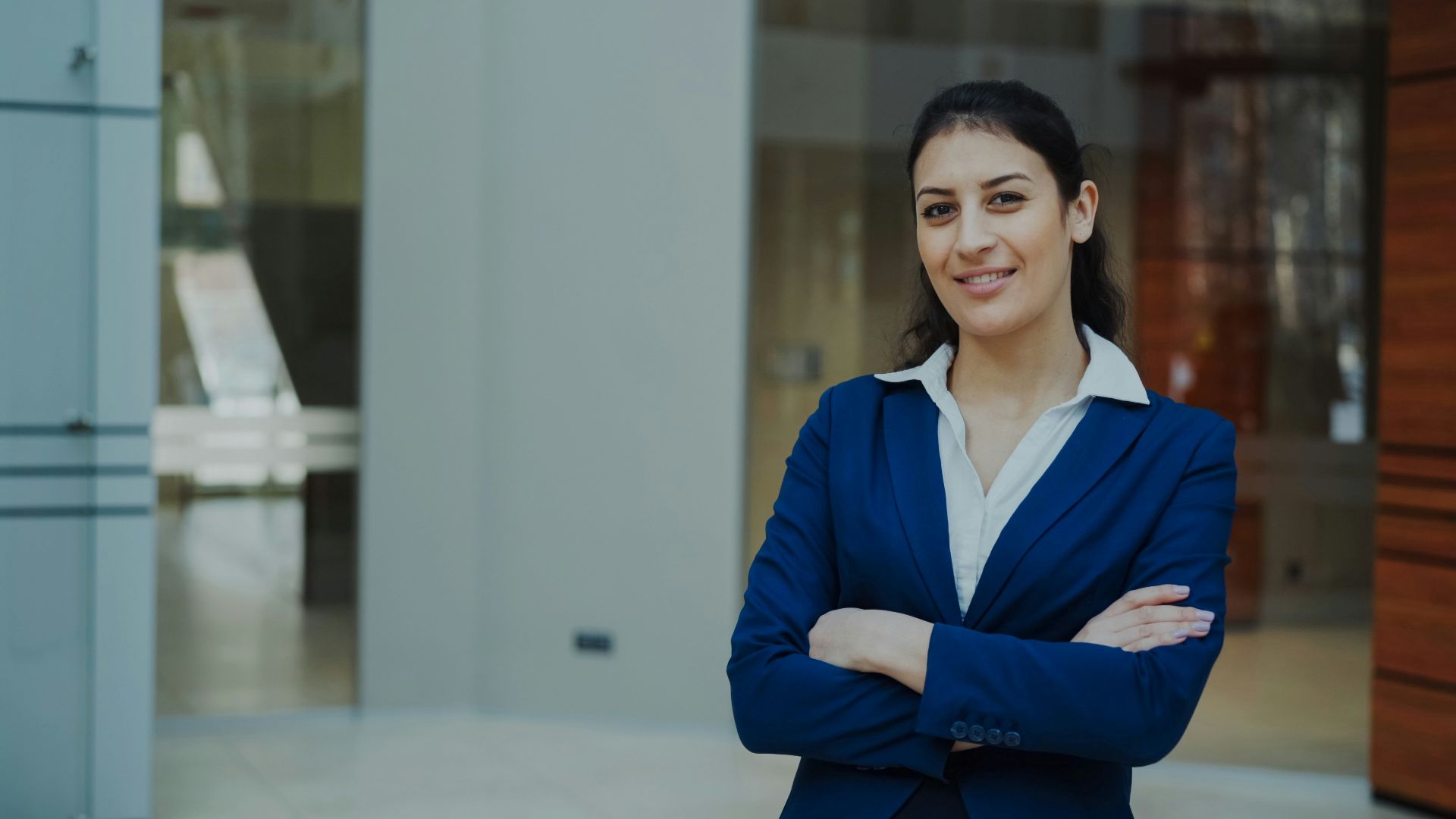 A confident businesswoman in a blue suit smiles