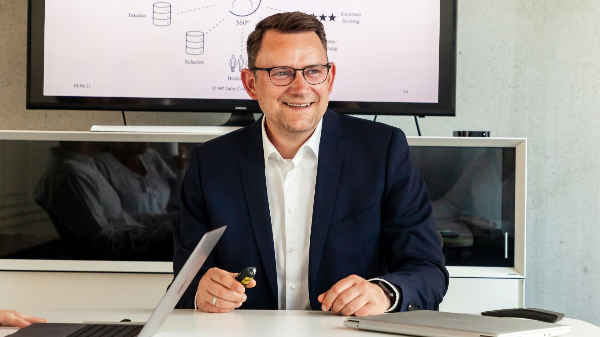 Man in suit smiling in a meeting room