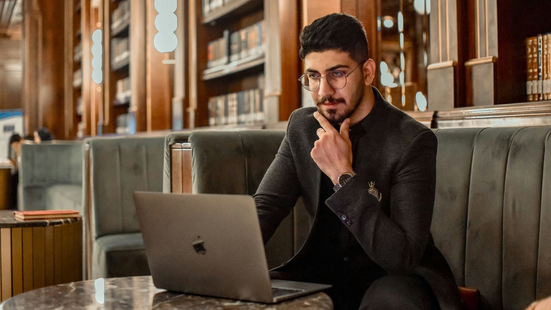 a man sitting on a couch using a laptop computer