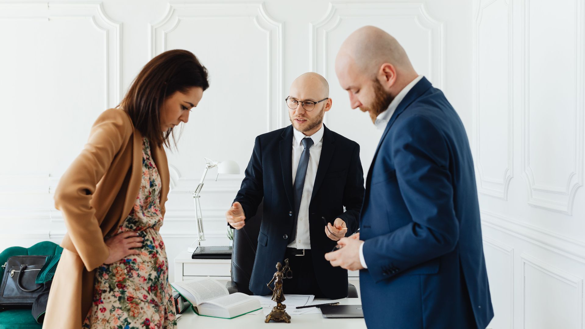 A lawyer meets with clients to discuss legal matters in a professional office setting.