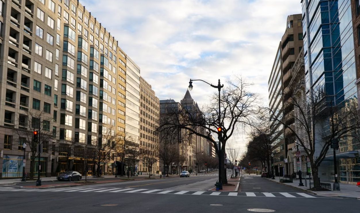 A deserted street in Washington DC showcasing modern urban architecture under a cloudy sky